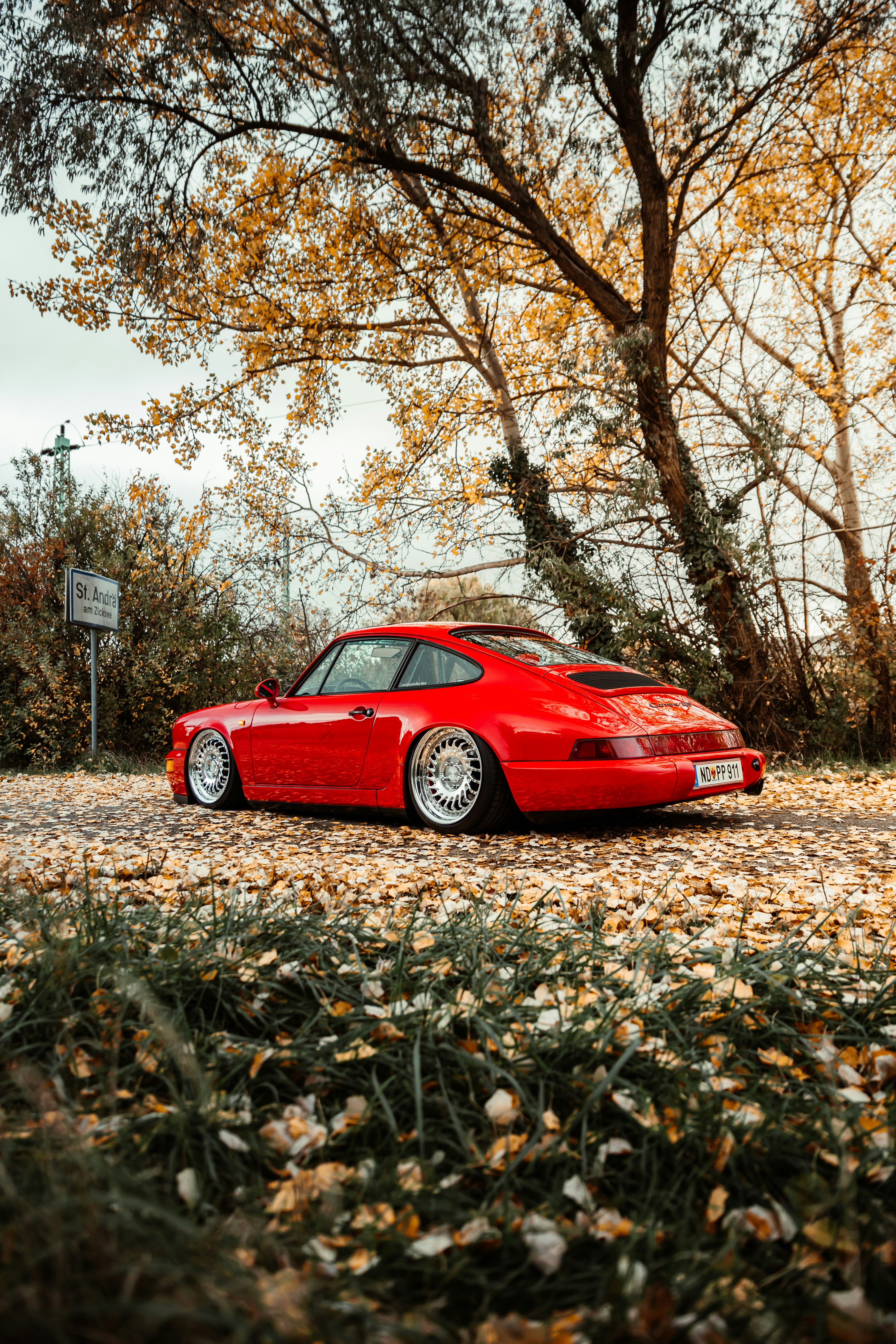 red ferrari coupe parked on brown grass field during daytime